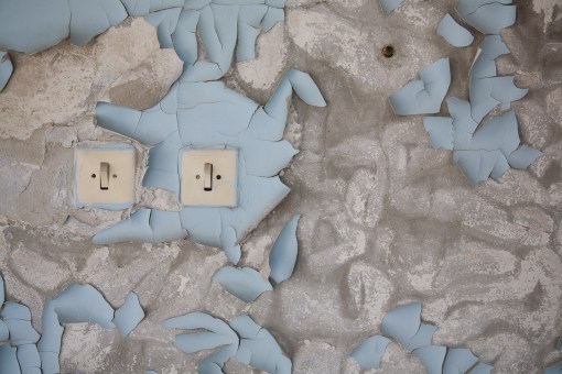 Light switches in a bedroom of Hotel Polissia. The peeling paint is the result of 21 years decay.