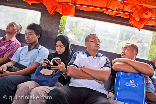 Sleeping, reading, watching. Bruneian Commuters take the water taxi through the mangrove swamps from Bangar to Bandar