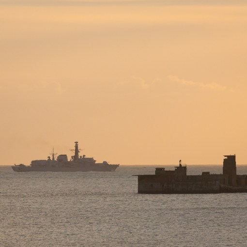 Frigate HMS Monmouth passes Portland Harbour Breakwater, Dorset.