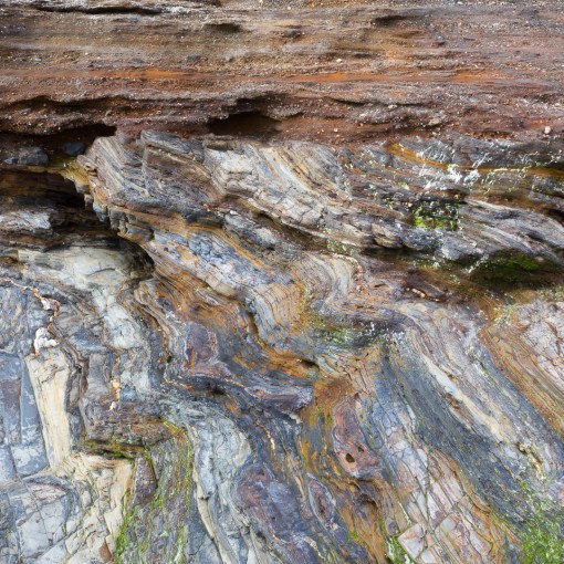 Raised Beach of round pebbles and sand resting on Devonian slates and shales. Pendower Beach, Cornwall.